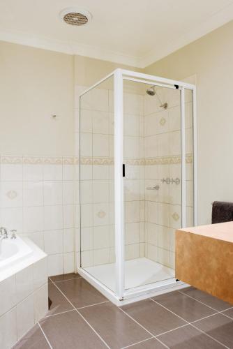 a shower with a glass door in a bathroom at Alexandra Place in Bendigo