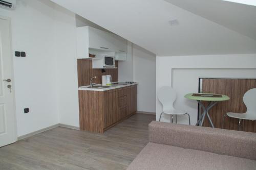 a living room with a kitchen and a table at Niš City Center Guest House in Niš