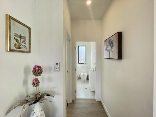 a hallway with white walls and a bathroom with a toilet at Your Modern Home in Sandringham, Close to City, Heat Pumps, Netflix, Parking in Auckland