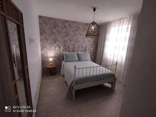 een slaapkamer met een bed en een hanglamp bij estancia de playa y golf in Punta Cana