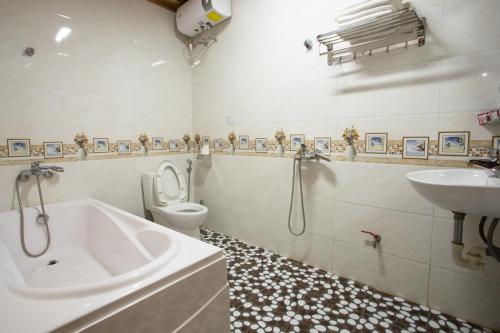 a bathroom with a tub and a toilet and a sink at Hang Lan Bungalow in Ninh Binh