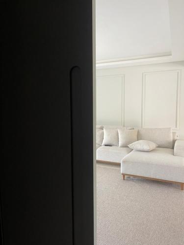 a living room with a white couch and a table at Casa com quarto disponível em Guaramirim in Guaramirim