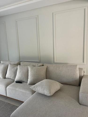 a white couch with pillows in a living room at Casa com quarto disponível em Guaramirim in Guaramirim