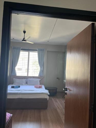 a bedroom with a bed and a window and a door at At par with 5 star hotel.. in Pune