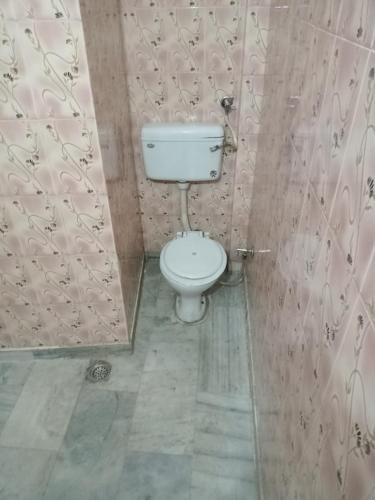 a bathroom with a white toilet in a room at Om Sai palace in Chandīgarh