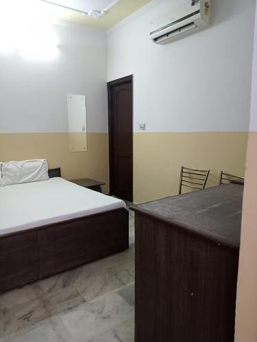 1 dormitorio con cama, mesa y puerta en Om Sai palace en Chandigarh