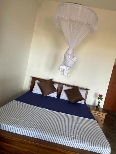 a bedroom with a bed with a blue comforter at Sea Garden Beach Resort in Habaraduwa Central