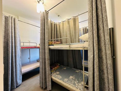 Pokój z 2 łóżkami piętrowymi i zasłonami w obiekcie OVAL TOWER w Dubaju