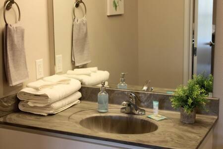 a bathroom sink with towels and a mirror at 4 mi to Jack Thrice Stadium + amenities in Ames