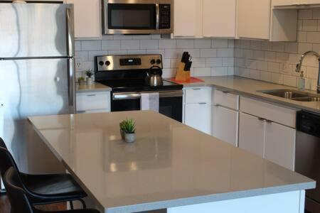 a kitchen with white cabinets and a white counter top at Onsite coffee bar just mins to Jack Thrice Stadium in Ames