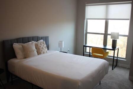1 dormitorio con 1 cama blanca grande y 1 silla en Onsite coffee bar just mins to Jack Thrice Stadium, en Ames