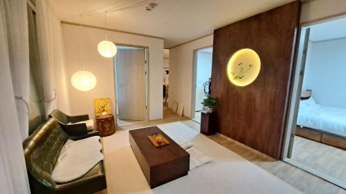 ein Wohnzimmer mit einem Sofa und einem Tisch in der Unterkunft Soban Stay in Busan