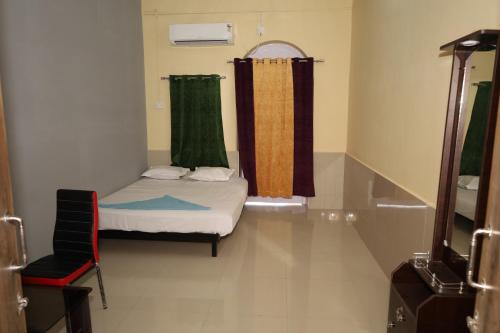 a small room with a bed and a window at RAIL NEST in Kharagpur