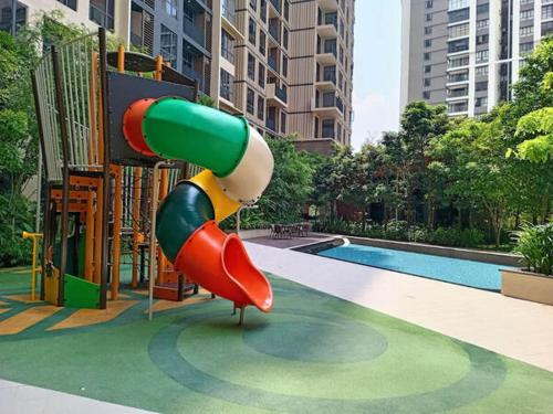 un tobogán en un parque infantil junto a una piscina en l Brand New Condo l I-Muslim Guesthouse Kuala Lumpur, en Kuala Lumpur