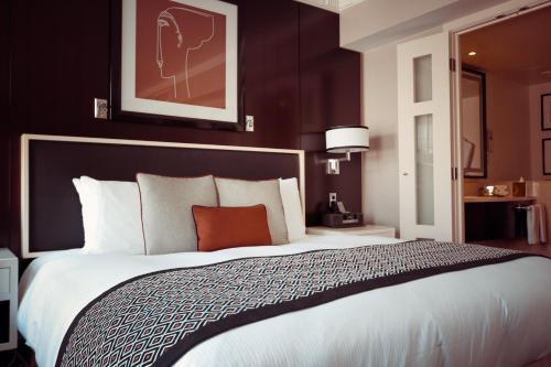Pokój hotelowy z dużym łóżkiem z białą pościelą w obiekcie New World Hotel w mieście Butwāl