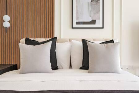 a bed with black and white pillows on it at Silkhaus Studio with Private Beach and Sea View in Abu Dhabi