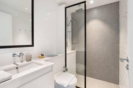 uma casa de banho com um WC, um lavatório e um chuveiro em Silkhaus Studio with Private Beach and Sea View em Abu Dhabi