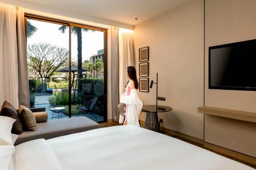 a woman is standing in a hotel room at Courtyard by Marriott Bangkok Suvarnabhumi Airport in Bangkok