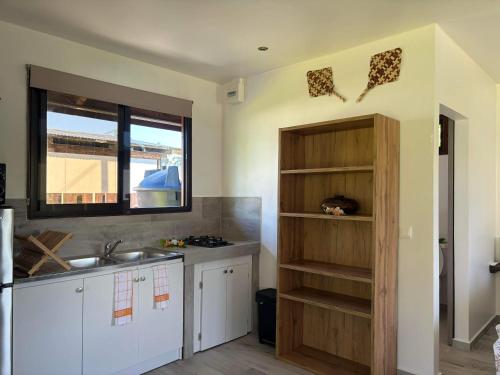 uma cozinha com um balcão, um lavatório e uma janela em Bungalow Kahaia Lodge em Avatoru