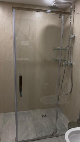 a shower with a glass door in a bathroom at Hotel Burabay in Shchūchīnsk