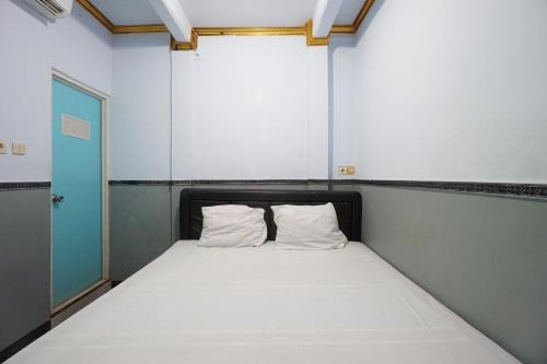 duże łóżko z 2 poduszkami w pokoju w obiekcie OYO 93628 Scorpion Guest House & Beach w mieście Tulungagung