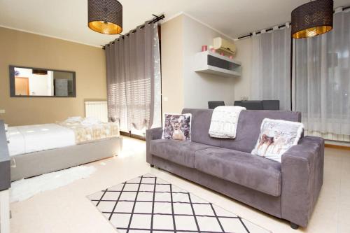 uma sala de estar com um sofá e uma cama em Comfort in Malpensa-Rho Fiera Milano 15 min em Legnano