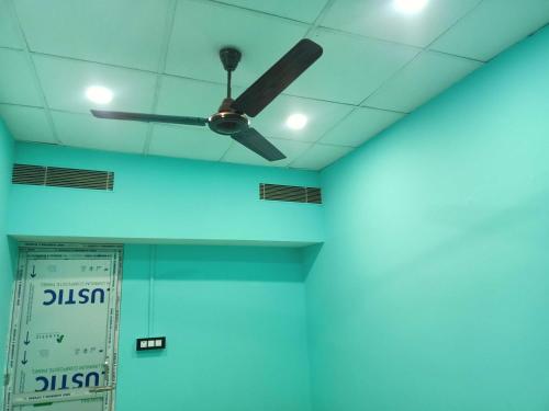a ceiling fan in a room with blue lights at Super OYO Flagship Sofitel Hotel in Dhanbād
