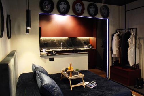 a living room with a couch and a kitchen with clocks at City Center Tirana Urban Condo in Tirana