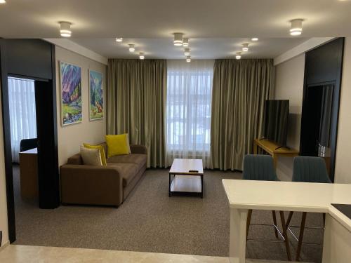 a living room with a couch and a table at Hotel Burabay in Shchūchīnsk