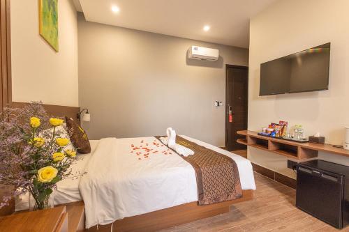 a hotel room with a bed with flowers on it at GREENECO DA LAT HOTEL - Khách sạn Green Eco Đà Lạt in Da Lat