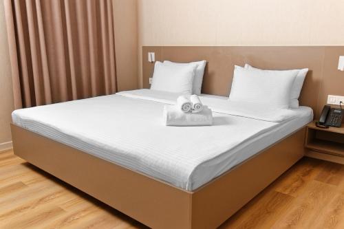 un letto con due asciugamani sopra di Aston Hotel ad Aqtau