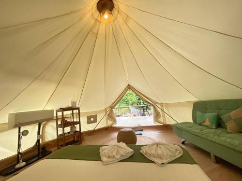 a tent with a bed and a couch in a room at Green Valley Veal Pouch in Kampot