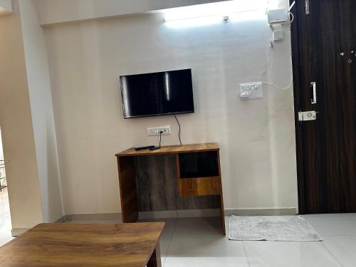 a living room with a tv on a wall at Blissful Stays in Pune