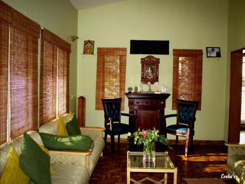 a living room with a couch and a table at LEELA's COUNTRY HOUSE in Kodaikānāl