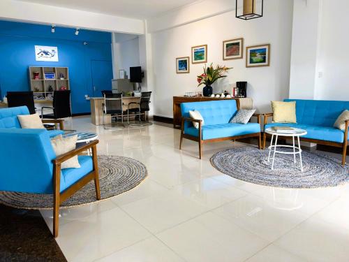 a waiting room with blue chairs and a table at Residence Le Point Choisy in Pointe aux Cannoniers