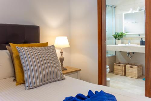 een slaapkamer met een bed met een wastafel en een spiegel bij Villa Angelita in Playa Blanca