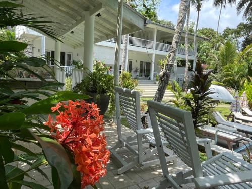 a group of chairs on a patio with a house at Plantation House in Hikkaduwa