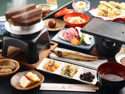 a table with plates of food and a coffee maker at Bandai in Tokamachi