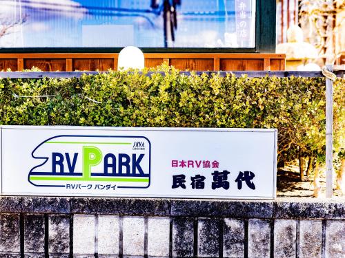 a rv park sign on a fence in front of a building at Bandai in Tokamachi