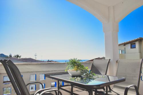 a table and chairs on a balcony with a view of the ocean at Varonos Summer Residences in Siviri