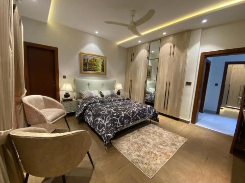 a bedroom with a bed and a chair at Firefly Retreat-your home away from home in Rawalpindi