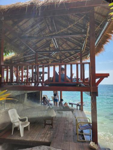 a man laying on a bed in a pavilion on the beach at Tao Thong Villa 2 in Ko Tao