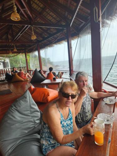 a man and a woman sitting at a table on a boat at Tao Thong Villa 2 in Ko Tao
