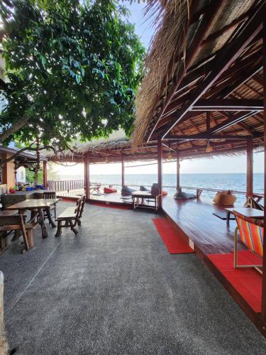 a pavilion with tables and chairs and the ocean at Tao Thong Villa 2 in Ko Tao