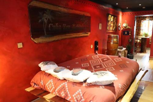 Un dormitorio rojo con una cama con toallas. en Apartment Cuba Zen Actitud, en Mouscron