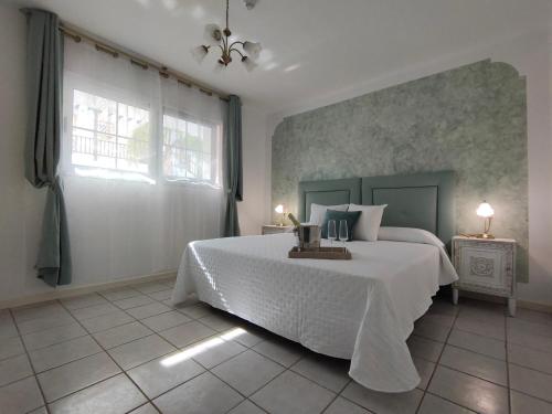 Un dormitorio con una cama blanca y una ventana. en Rocas del Mar 327, en Costa del Silencio