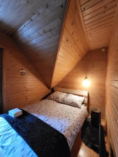 a bedroom with a bed in a wooden cabin at domek w zaczarowanym lesie in Istebna