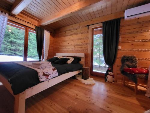 a bedroom with a bed in a log cabin at domek w zaczarowanym lesie in Istebna