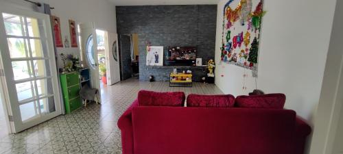 a living room with a red couch and a kitchen at บ้านพักในสวนK&N2 