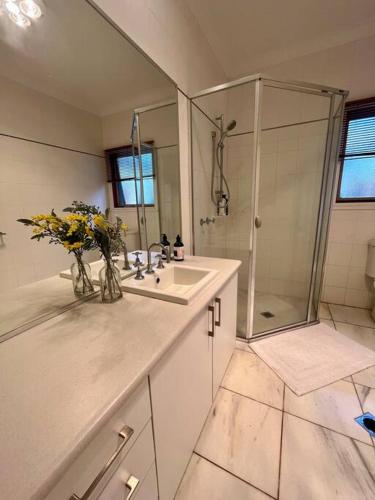 a bathroom with a sink and a shower with flowers at Grand retreat in town in Albury